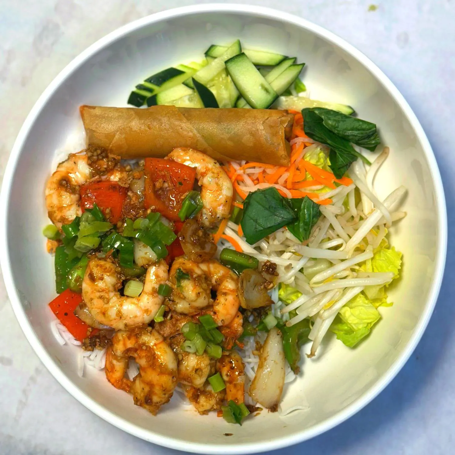 Spicy shrimp vermicelli bowl with egg roll and crisp veggies at Magnolia Pho, a Vietnamese Restaurant in Seattle