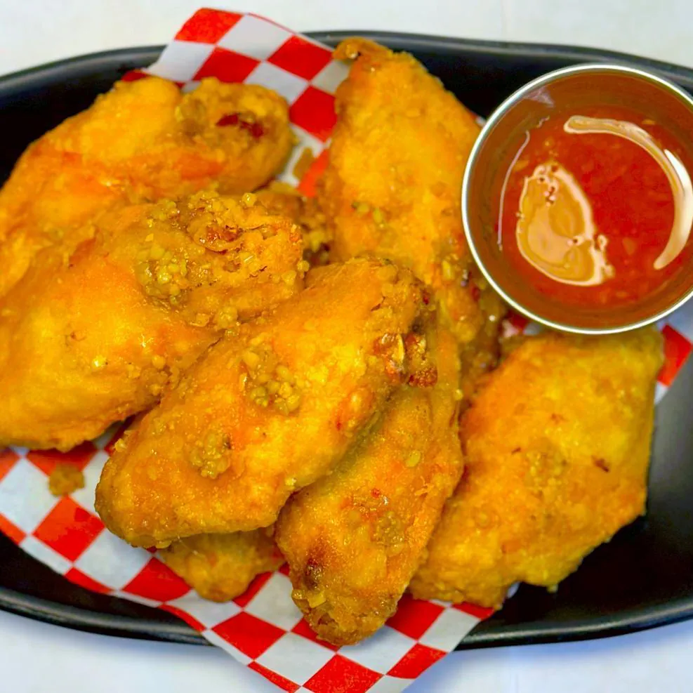 Crispy chicken wings served with tangy dipping sauce at Magnolia Pho, a Vietnamese Restaurant in Seattle