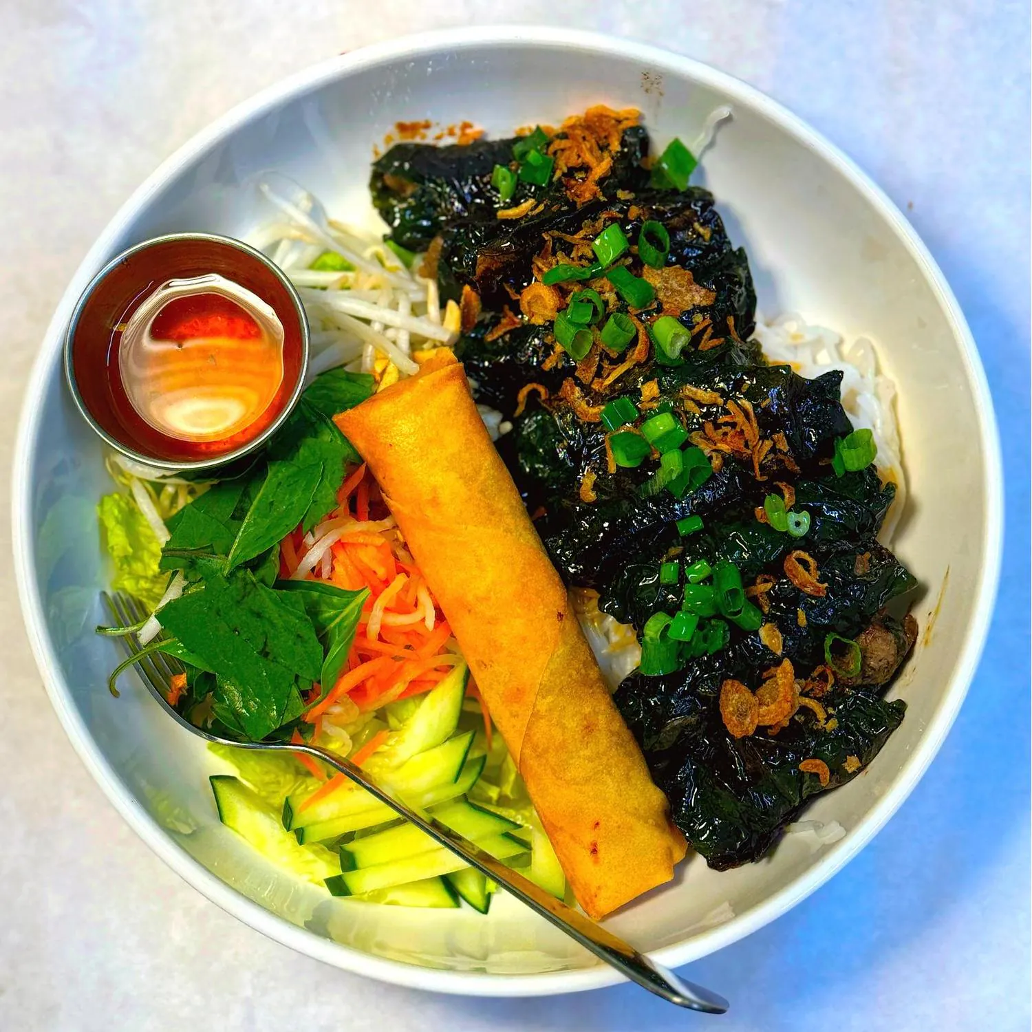 Vietnamese bowl with egg roll, veggies and dipping sauce at Magnolia Pho, a Vietnamese Restaurant in Seattle