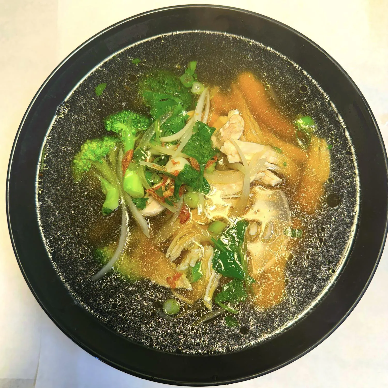 Chicken noodle soup with broccoli and fresh herbs at Magnolia Pho, a Vietnamese Restaurant in Seattle